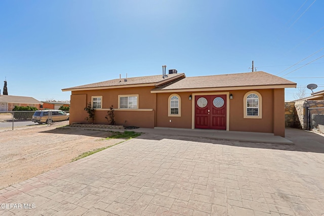 view of front of house with fence and stucco siding