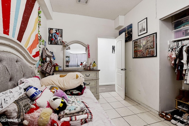 bedroom with light tile patterned floors and visible vents