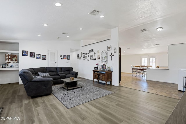 living area with visible vents, recessed lighting, and wood finished floors