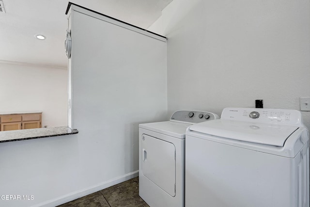 washroom with visible vents, baseboards, laundry area, and washing machine and clothes dryer