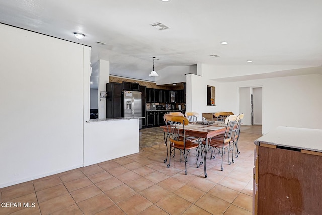 dining space featuring visible vents, lofted ceiling, and light tile patterned flooring