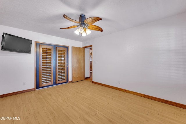 unfurnished bedroom with baseboards, visible vents, light wood finished floors, and ceiling fan