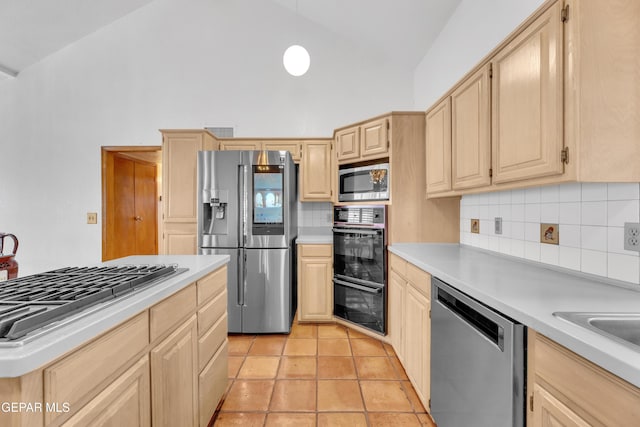 kitchen with light brown cabinets, light tile patterned flooring, decorative backsplash, light countertops, and appliances with stainless steel finishes