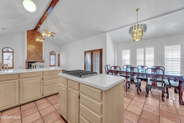 kitchen featuring stainless steel gas cooktop, plenty of natural light, a center island, and lofted ceiling with beams