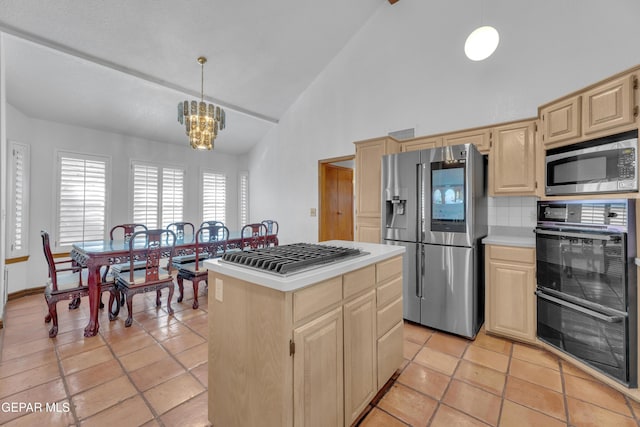 kitchen featuring light countertops, a kitchen island, light brown cabinetry, and stainless steel appliances