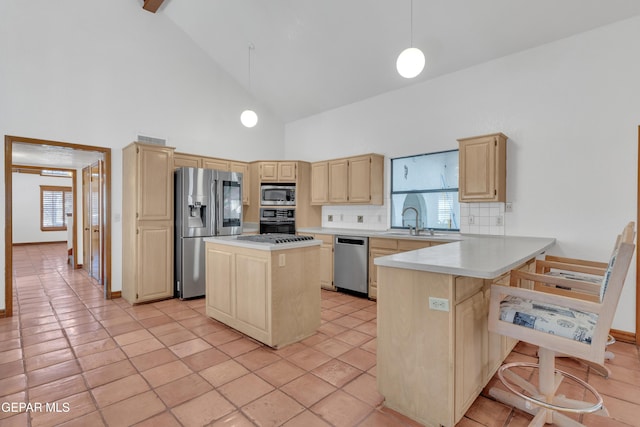 kitchen with a sink, appliances with stainless steel finishes, a peninsula, and light brown cabinets