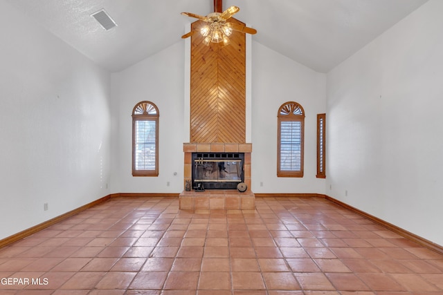 unfurnished living room with visible vents, high vaulted ceiling, light tile patterned flooring, baseboards, and a tile fireplace