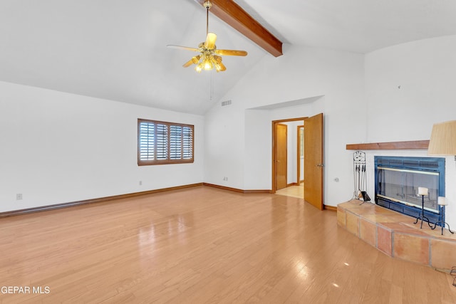 unfurnished living room with visible vents, beam ceiling, high vaulted ceiling, wood finished floors, and a tile fireplace