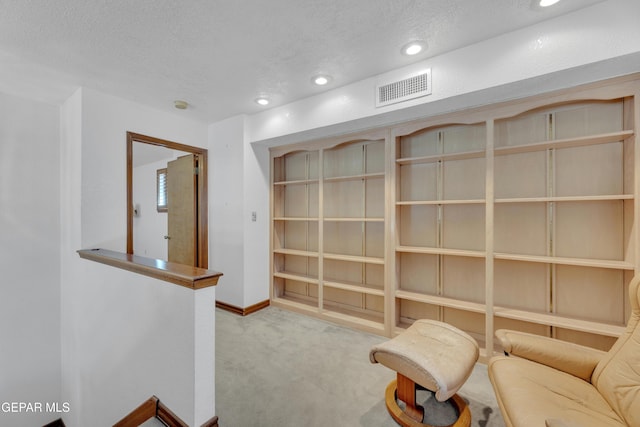 unfurnished room featuring visible vents, a textured ceiling, recessed lighting, carpet floors, and baseboards