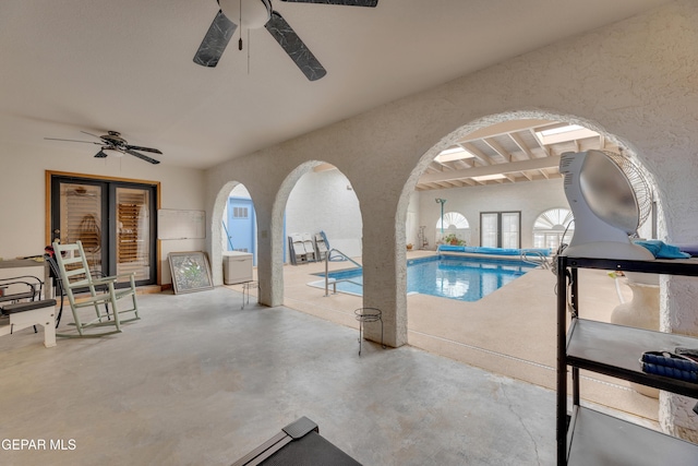 view of pool with a ceiling fan and arched walkways