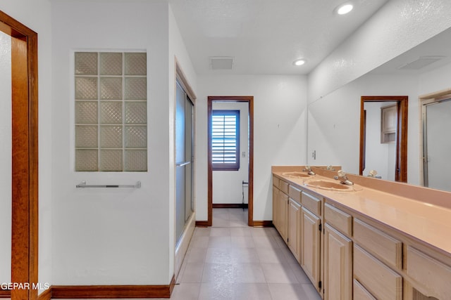 bathroom featuring vanity, visible vents, a shower with shower door, baseboards, and recessed lighting