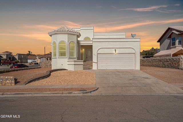 view of front of property with stucco siding, driveway, and an attached garage