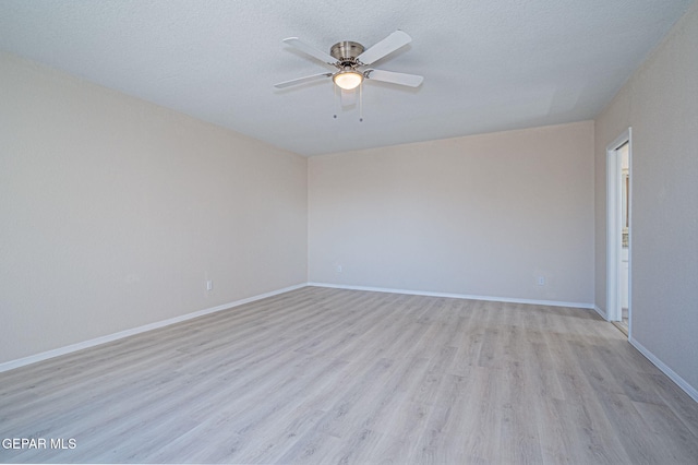 unfurnished room featuring ceiling fan, baseboards, a textured ceiling, and light wood-style flooring