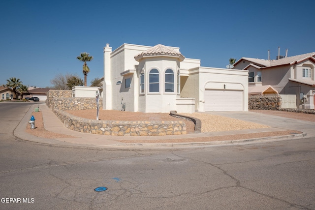 mediterranean / spanish home with stucco siding, concrete driveway, an attached garage, and a tile roof