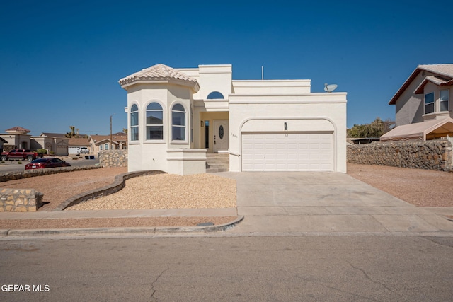 view of front of home with stucco siding, concrete driveway, an attached garage, and a tile roof