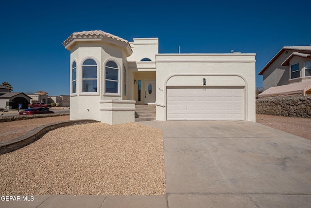 view of front of property with a tile roof, concrete driveway, a garage, and stucco siding