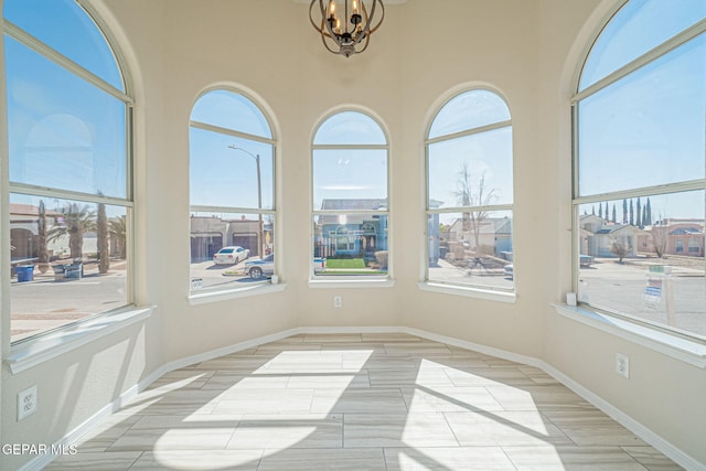 sunroom / solarium featuring a wealth of natural light and a notable chandelier