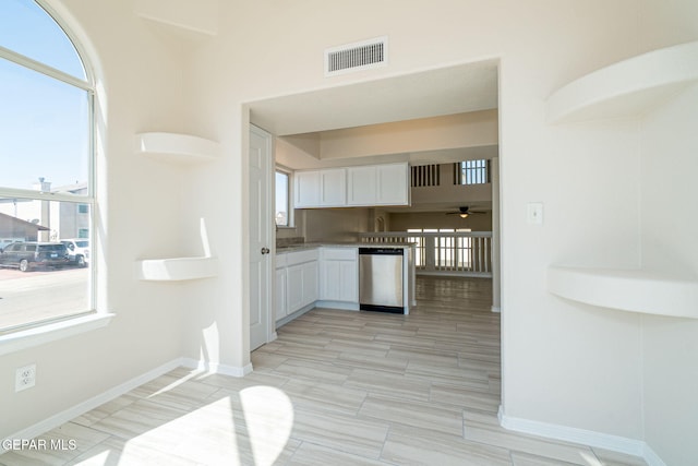 kitchen featuring baseboards, visible vents, open shelves, white cabinets, and stainless steel dishwasher