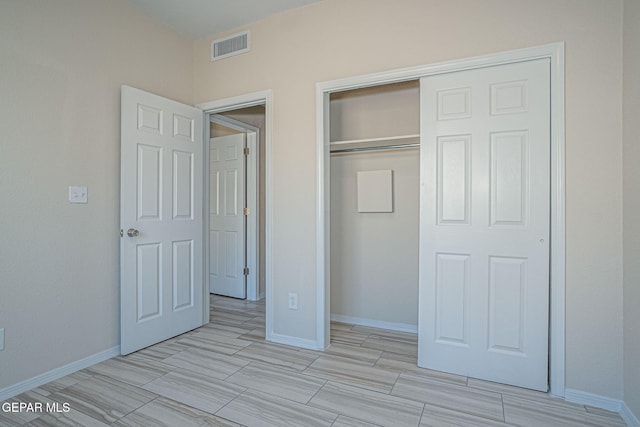 unfurnished bedroom featuring a closet, visible vents, and baseboards