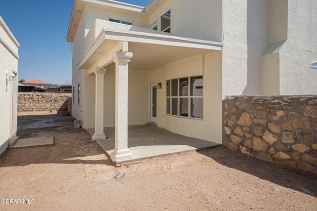 exterior space featuring a patio, fence, and stucco siding