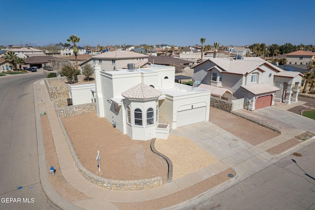 view of front of house featuring a residential view, stucco siding, a tiled roof, and concrete driveway