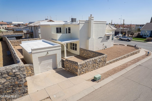 view of front of home featuring cooling unit, driveway, and stucco siding