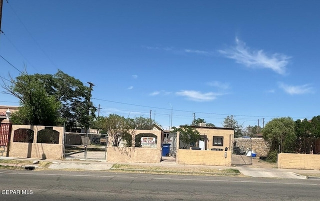 view of front facade featuring a gate, a fenced front yard, and stucco siding