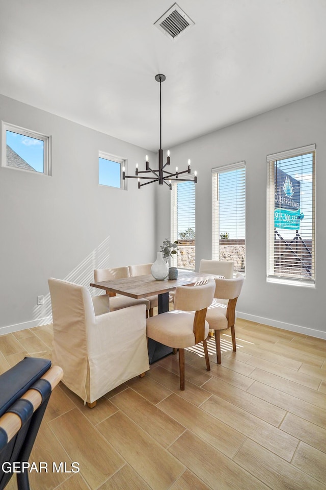 dining room with wood finish floors, visible vents, plenty of natural light, and a chandelier