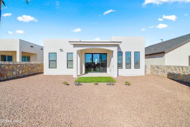 rear view of house featuring stucco siding and a patio area