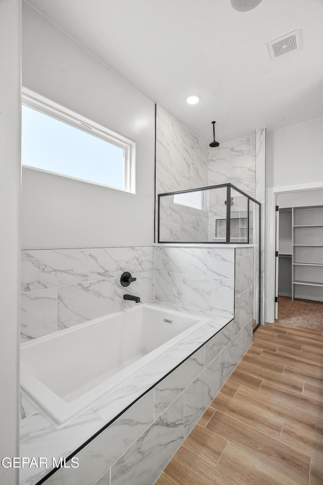 full bath featuring a marble finish shower, visible vents, wood tiled floor, a garden tub, and recessed lighting