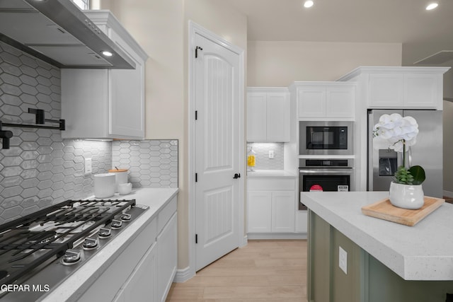 kitchen featuring tasteful backsplash, recessed lighting, stainless steel appliances, white cabinets, and light wood finished floors