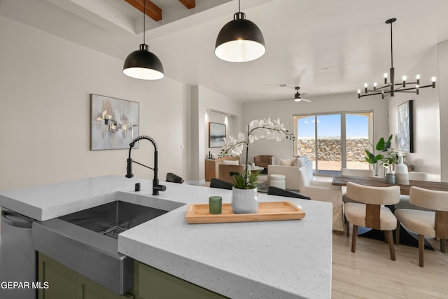 kitchen with light wood finished floors, green cabinets, dishwasher, beam ceiling, and a sink