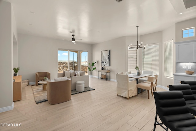 living area featuring baseboards, light wood-type flooring, and a wealth of natural light