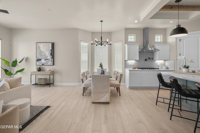 dining space featuring recessed lighting, light wood-type flooring, baseboards, and an inviting chandelier