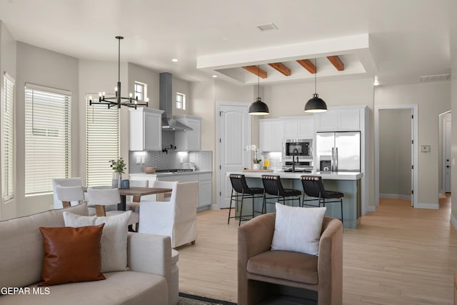 living area featuring a notable chandelier, visible vents, and light wood-style floors