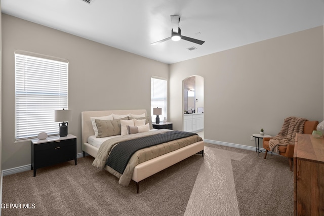 bedroom featuring visible vents, baseboards, arched walkways, ceiling fan, and light colored carpet