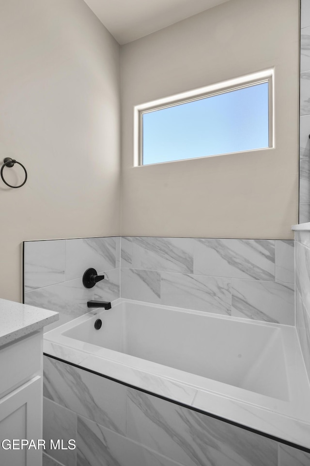 bathroom featuring vanity and a garden tub