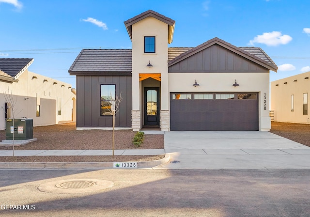 view of front of property featuring board and batten siding, a tile roof, cooling unit, driveway, and an attached garage