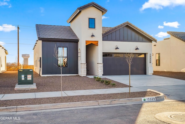 view of front of house with a tile roof, a garage, board and batten siding, and driveway