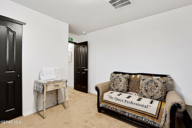 living area with visible vents, baseboards, and light colored carpet