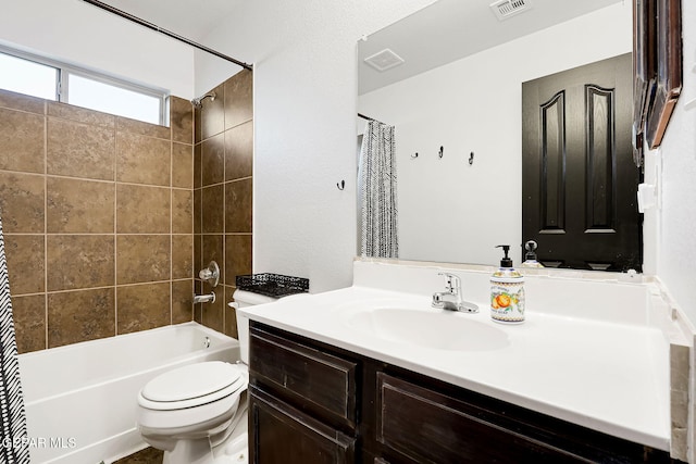 bathroom with visible vents, vanity, toilet, and shower / tub combo