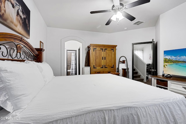 bedroom with arched walkways, visible vents, and a ceiling fan