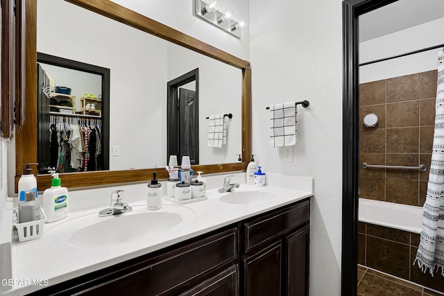 bathroom featuring a sink, tiled shower / bath combo, and double vanity