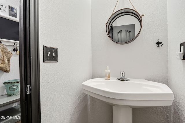 bathroom with a textured wall and a sink