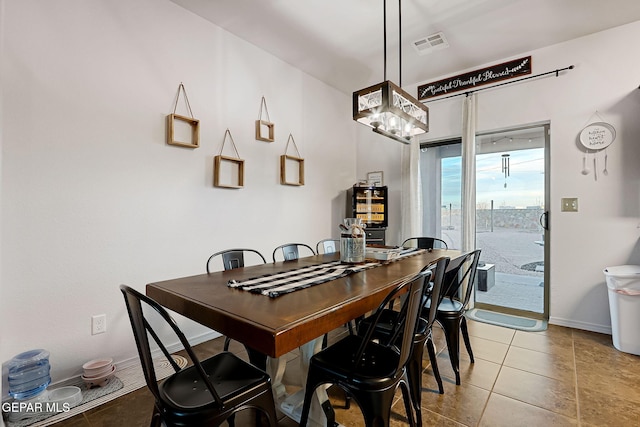 tiled dining area featuring visible vents, baseboards, and a notable chandelier