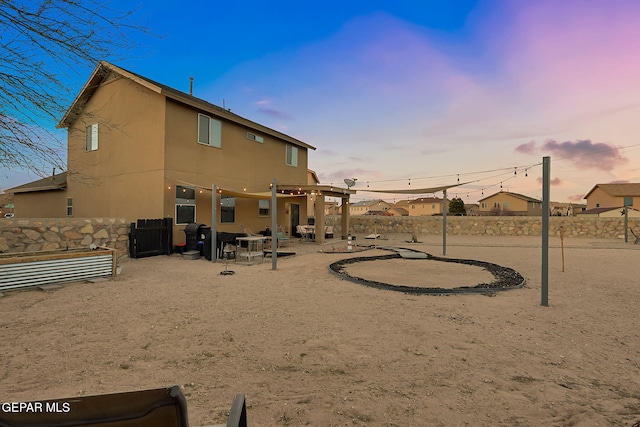 rear view of property with stucco siding, a patio, and fence