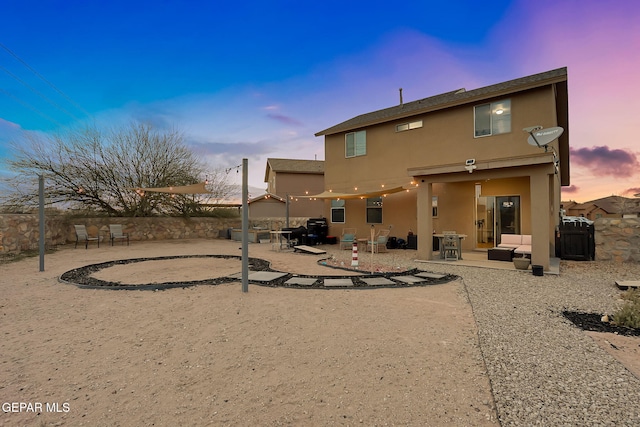 back of property with stucco siding, a patio, and fence