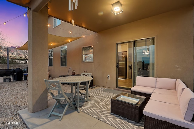 patio terrace at dusk with outdoor dining space and outdoor lounge area