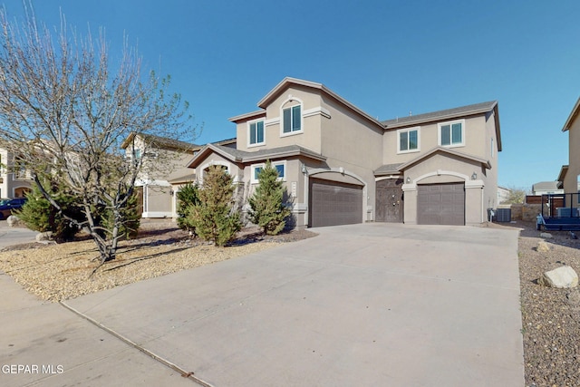 view of front of property featuring an attached garage, fence, driveway, and stucco siding