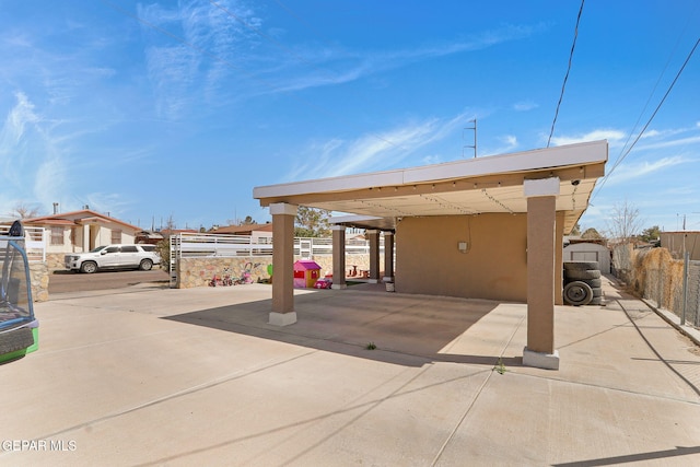 exterior space featuring a carport and fence